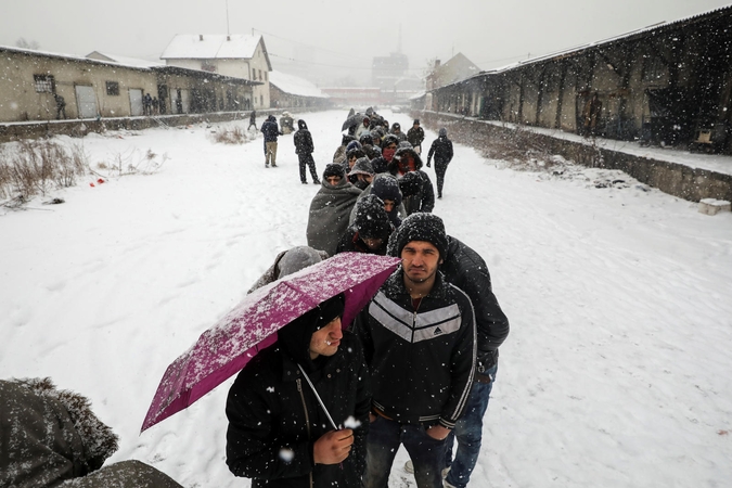Belgrade migrantai stovėdami pūgoje laukia šilto maisto