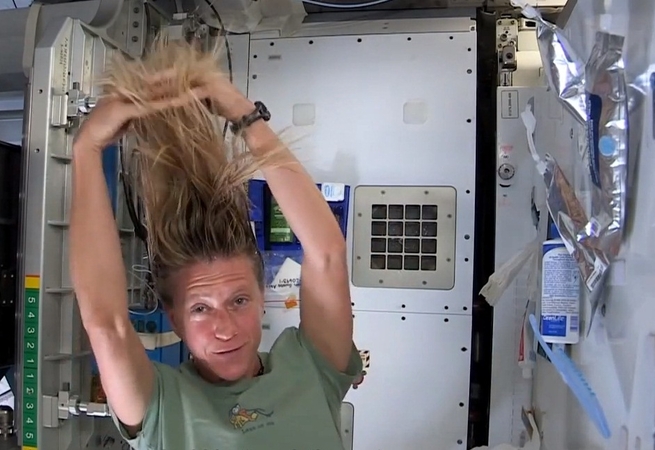 Astronautė demonstruoja, kaip kosmose plaunami plaukai
