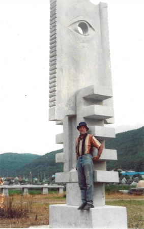 A. Bosas prie kūrinio „Raktas į dangų“ (2002 m., granitas, 600 X 180 X 100 cm, Busanas, Pietų Korėja).